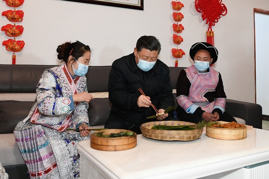 2021年2月3日下午，習(xí)近平在貴州畢節(jié)市黔西縣新仁苗族鄉(xiāng)化屋村苗族村民趙玉學(xué)家，同一家人邊聊家常邊制作當(dāng)?shù)貍鹘y(tǒng)節(jié)日食品黃粑。新華社記者 李學(xué)仁 攝