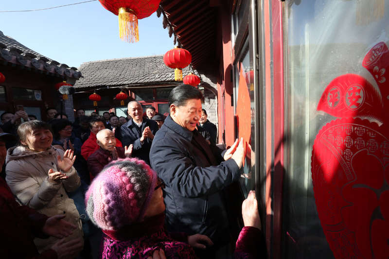 2019年2月1日上午，習(xí)近平在北京前門東區(qū)草廠四條胡同32號院，高興地拿起一幅“?！弊?，親自貼到門上，給這里的老街坊們拜年。新華社記者 鞠鵬 攝