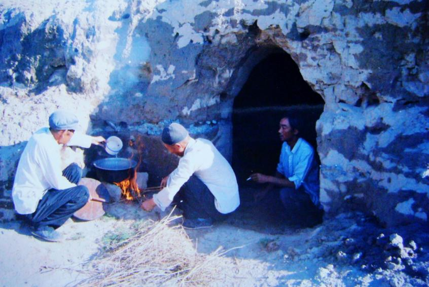 1983年，“六老漢”一代治沙人在“地窩子”生活做飯。新華社發(fā)（八步沙林場供圖）