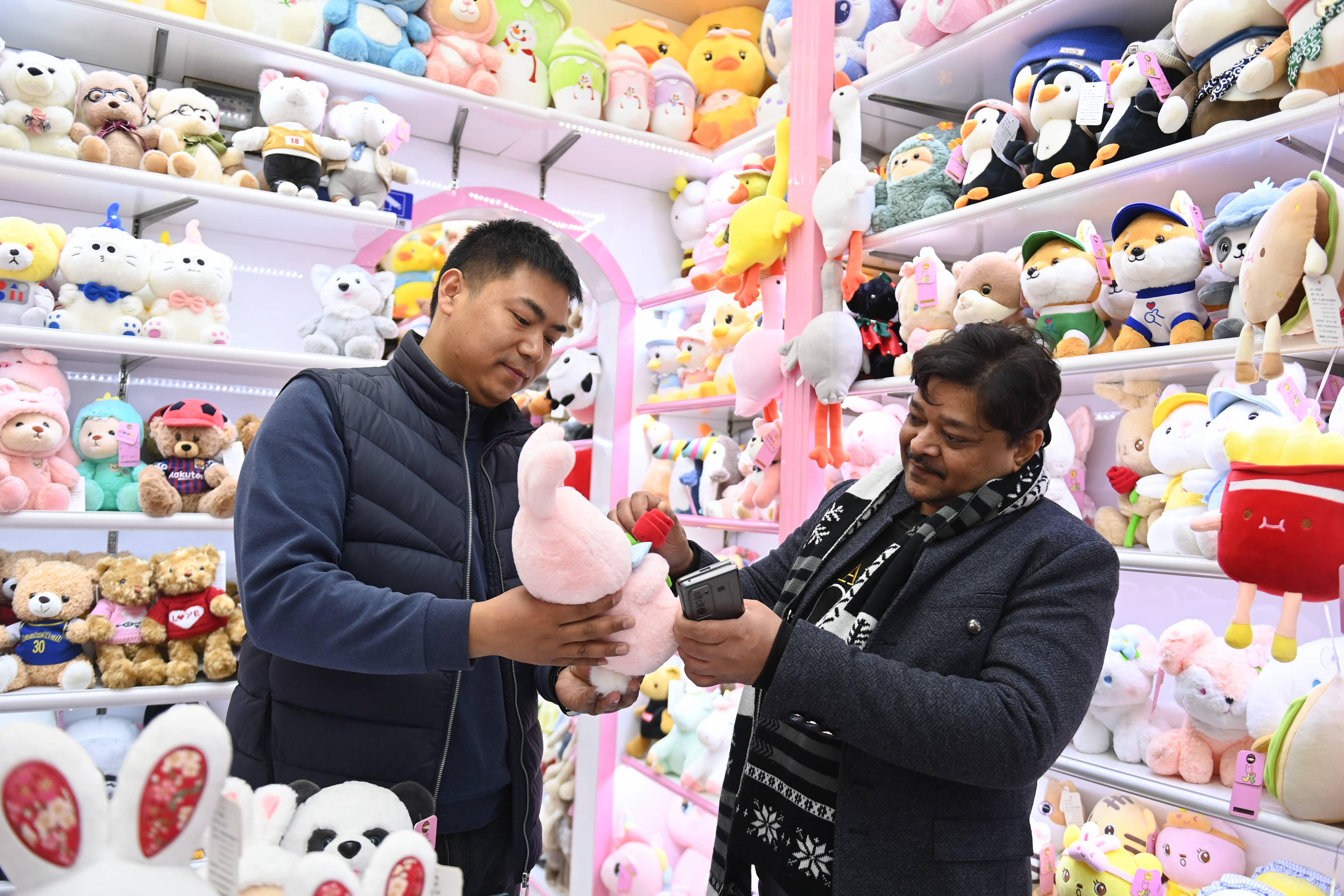 2023年2月2日，來(lái)自印度的客商（右）在義烏國(guó)際商貿(mào)城的一家玩具店鋪內(nèi)選購(gòu)。